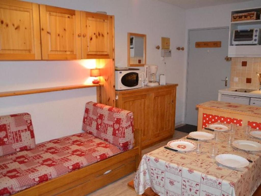 a room with a kitchen and a table with plates on it at Appartement Les Menuires, 1 pièce, 4 personnes - FR-1-452-31 in Les Menuires