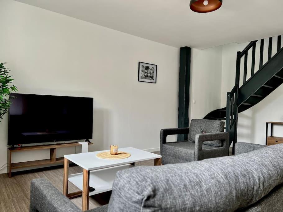 a living room with a couch and two chairs and a tv at La Parisienne - 80m2 in Vierzon