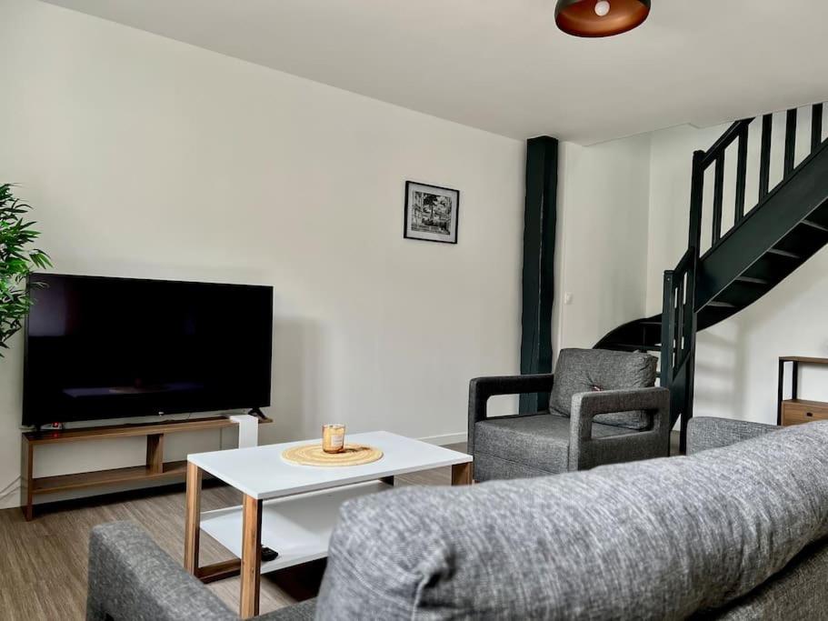 salon z kanapą, 2 krzesłami i telewizorem w obiekcie La Parisienne - 80m2 w mieście Vierzon