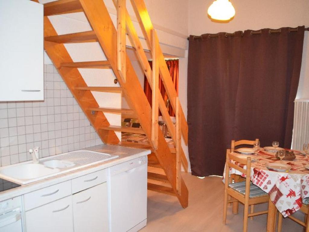 a kitchen with a staircase and a table and a kitchen with a tableablish at Appartement Les Menuires, 2 pièces, 6 personnes - FR-1-452-119 in Les Menuires