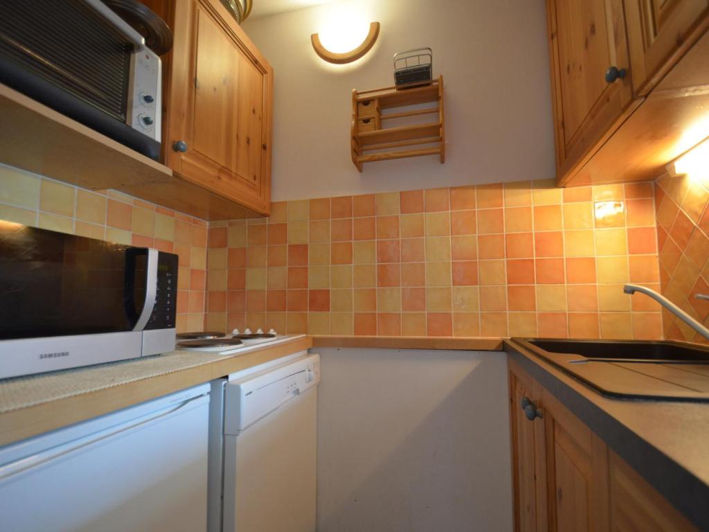 uma cozinha com um micro-ondas e um lavatório em Appartement Les Menuires, 3 pièces, 10 personnes - FR-1-452-239 em Les Menuires