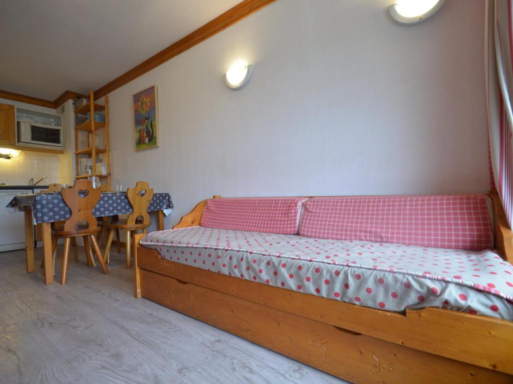 a bedroom with a bed and a table and chairs at Appartement Les Menuires, 2 pièces, 4 personnes - FR-1-452-253 in Les Menuires