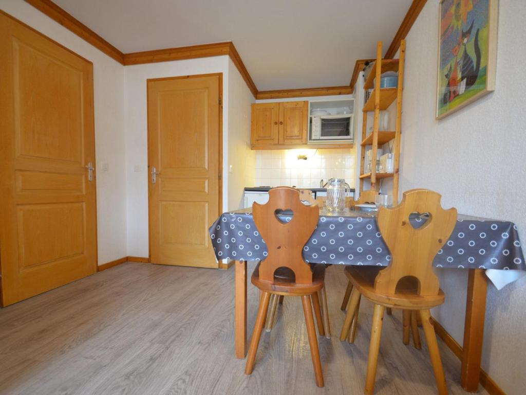 a kitchen with a table and two wooden chairs at Appartement Les Menuires, 2 pièces, 4 personnes - FR-1-452-253 in Les Menuires