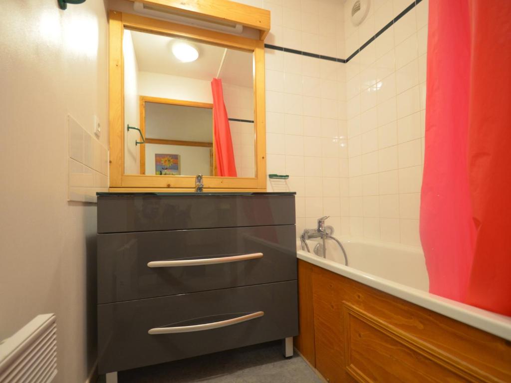 a bathroom with a sink and a mirror and a tub at Appartement Les Menuires, 2 pièces, 4 personnes - FR-1-452-253 in Les Menuires