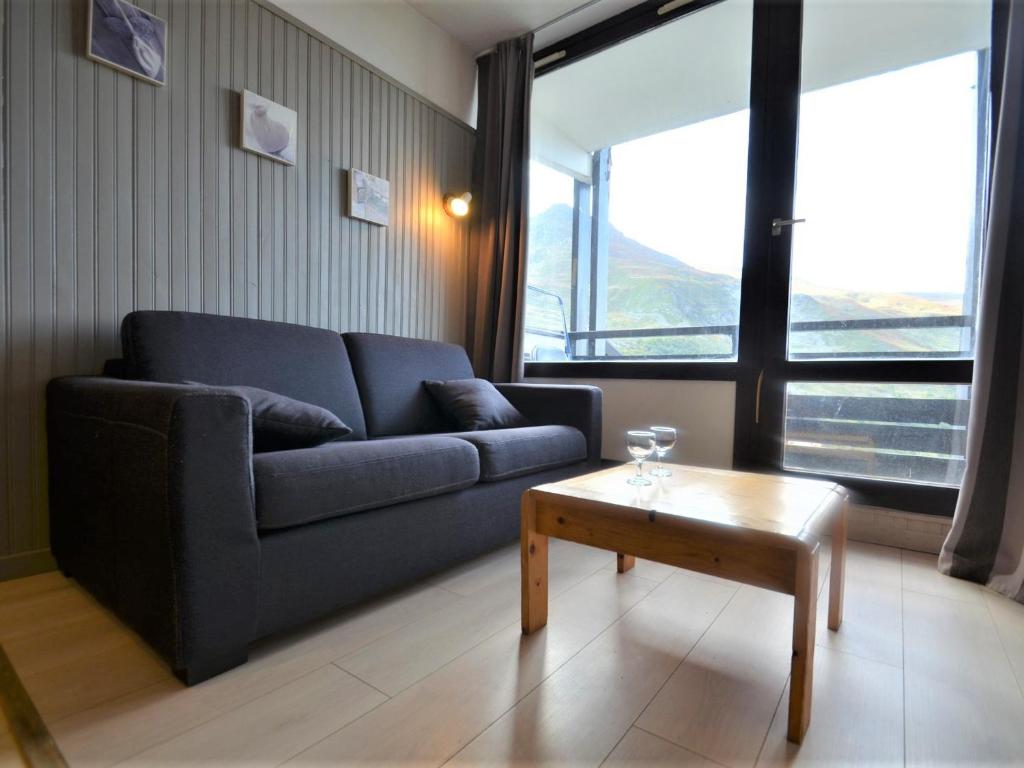 a living room with a blue couch and a coffee table at Studio Les Menuires, 1 pièce, 4 personnes - FR-1-452-262 in Les Menuires