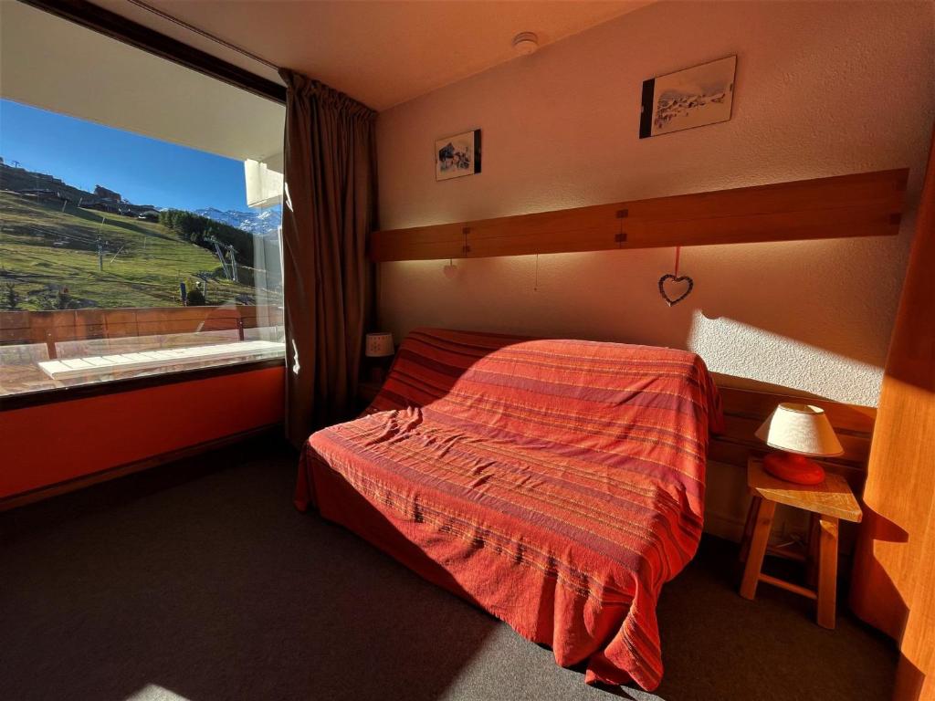 ein Schlafzimmer mit einem Bett und einem großen Fenster in der Unterkunft Studio Les Menuires, 1 pièce, 4 personnes - FR-1-452-190 in Les Menuires