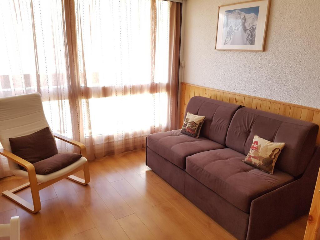 un salon avec un canapé et une chaise dans l'établissement Studio confortable aux Menuires pour 3 personnes avec balcon - FR-1-452-227, aux Menuires