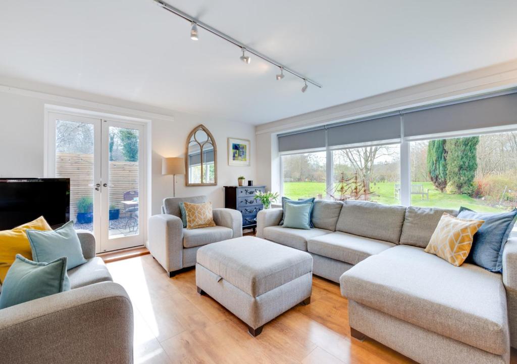 a living room with a couch and chairs and windows at Little Bourne in Tonbridge