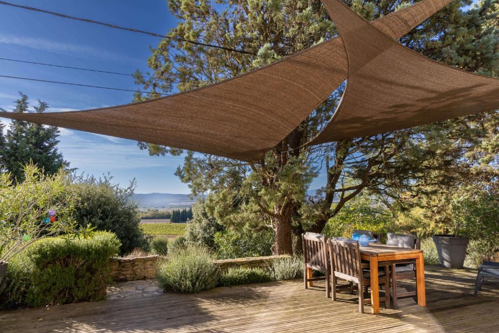 a patio with a table and chairs under a mosquito net at Domaine de la Bade in Raissac-sur-Lampy