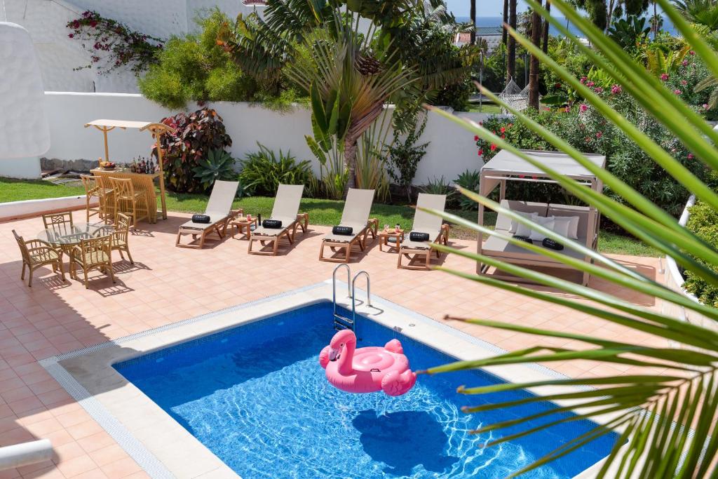a swimming pool with a pink flamingo in a backyard at KARAT Villa Atlantida in Playa de las Americas