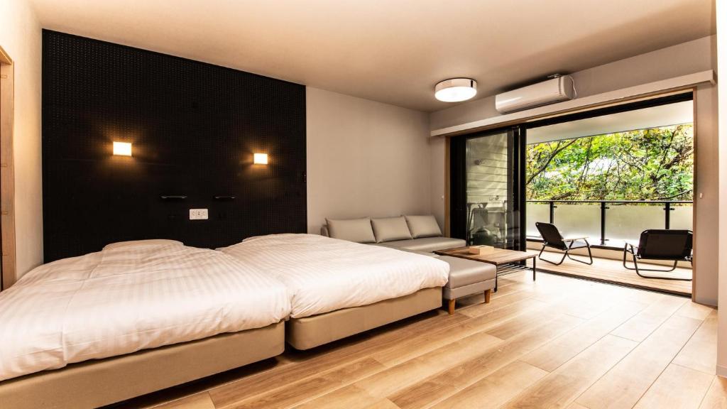 Rakuten STAY MOTEL Nikko Kinugawa Standard Room في نيكو: غرفة نوم بسرير كبير وغرفة معيشة