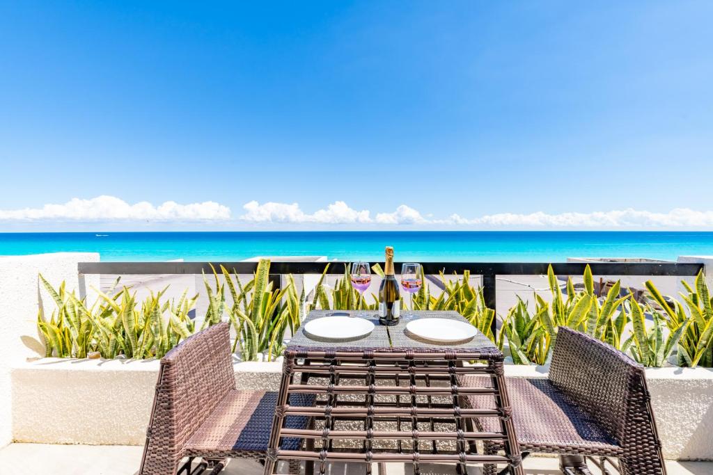 Cancun Ocean view في كانكون: طاولة وكراسي مع المحيط في الخلفية