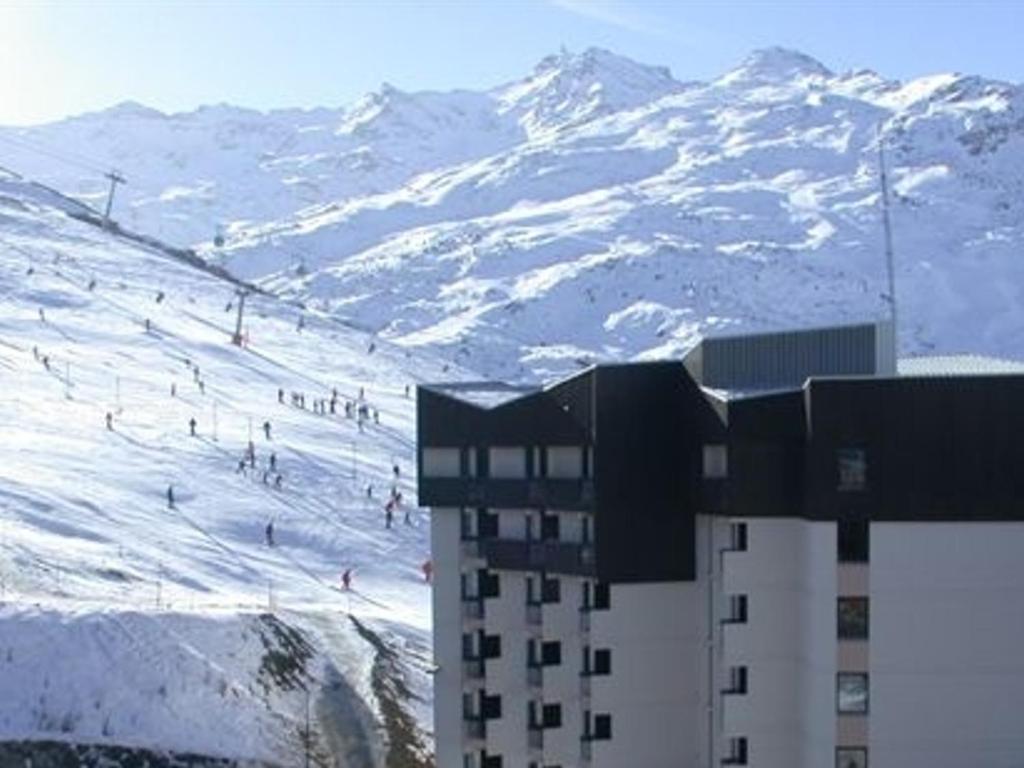 a building in front of a snow covered mountain at Studio Les Menuires, 1 pièce, 2 personnes - FR-1-452-144 in Les Menuires