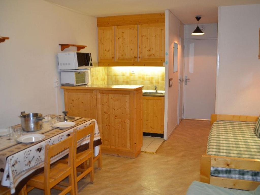 a kitchen with a table and a stove top oven at Studio Les Menuires, 1 pièce, 3 personnes - FR-1-452-191 in Les Menuires