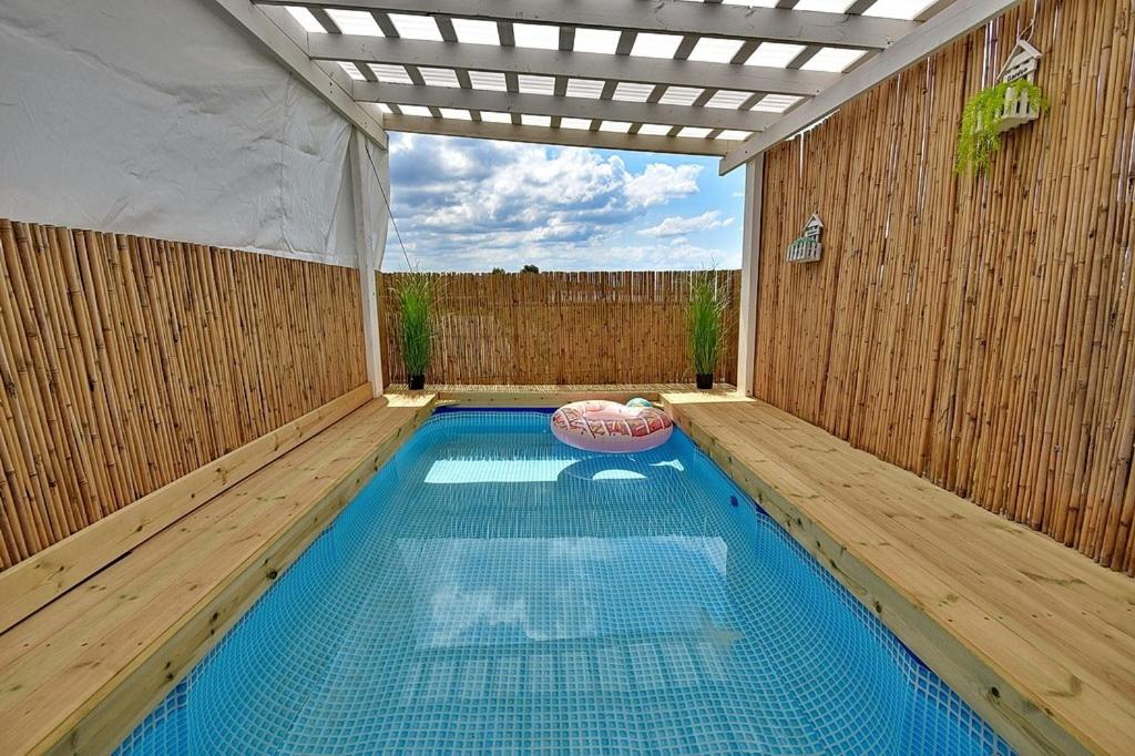 a swimming pool in a backyard with a wooden fence at סוויטת פנינת הים in Shelomi