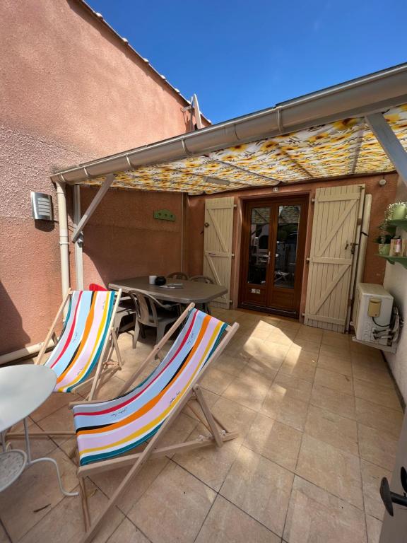 une paire de chaises et une table sur une terrasse dans l'établissement La maisonnette de Gruissan, à Gruissan