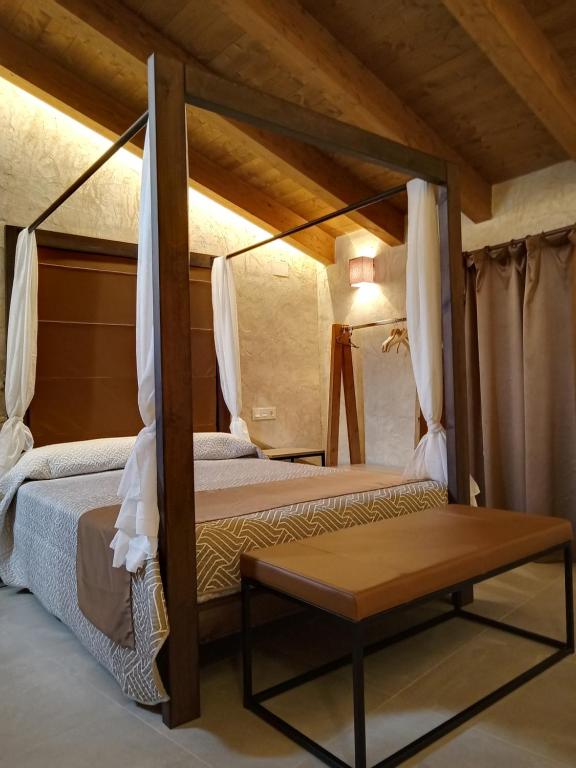 a bedroom with two beds and a table at Casa rural El Forn d'Alcudia de Veo in Alcudia de Veo