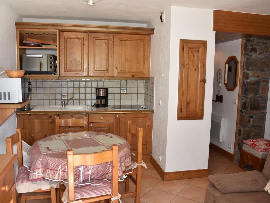 une cuisine avec une table et un évier et une table et des chaises dans l'établissement Appartement 3 pièces avec terrasse, parking et accès pistes – Pralognan - FR-1-464-190, à Pralognan-la-Vanoise