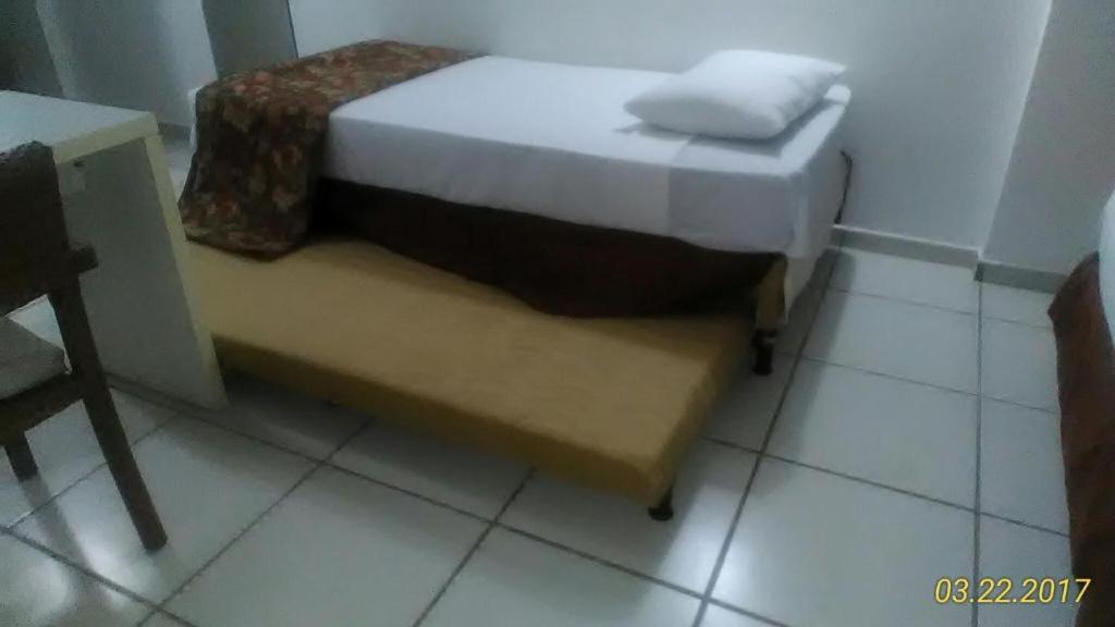 a small bed and a bench in a room at Flat Le Jardin Suites in Caldas Novas