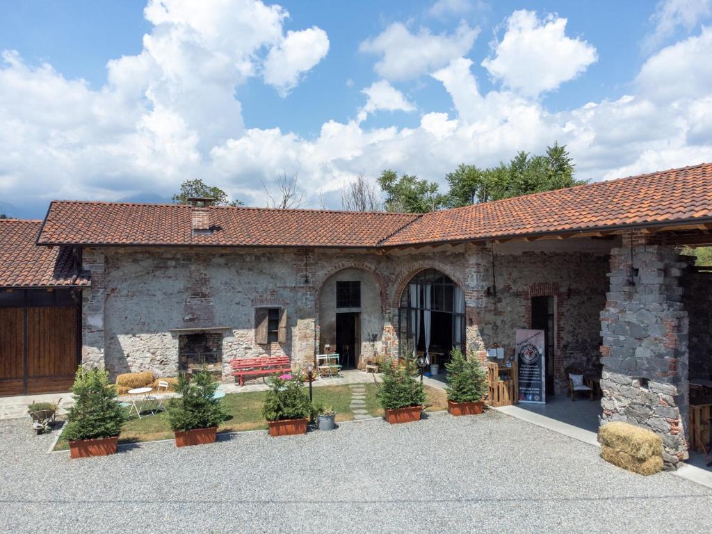 ein altes Steingebäude mit Topfpflanzen im Innenhof in der Unterkunft B&b Il Cortile in Biella
