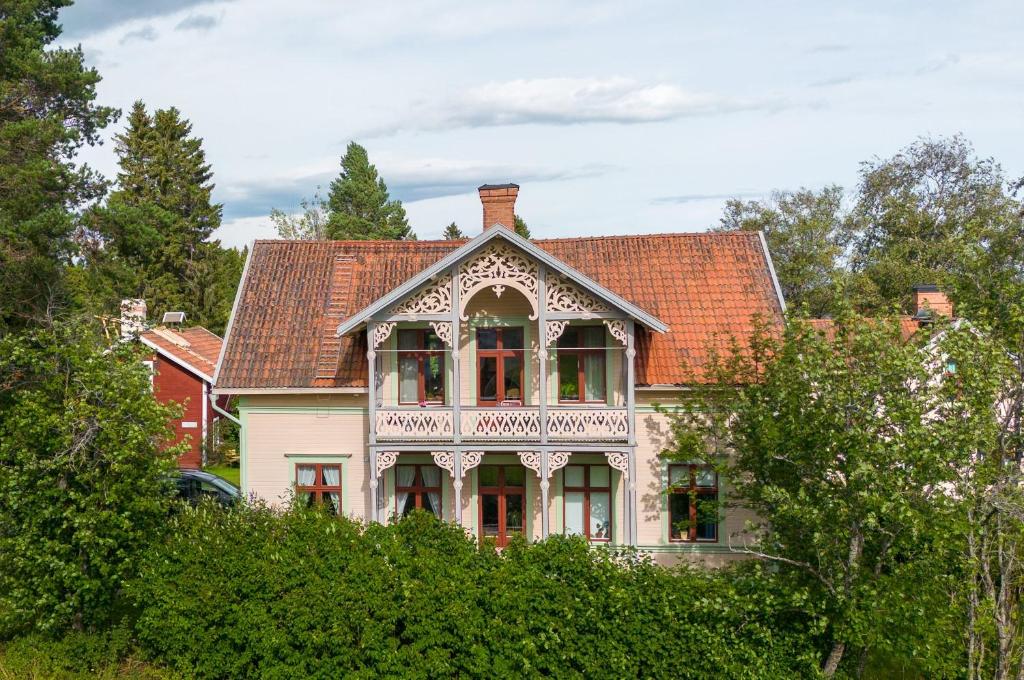 una casa antigua con balcón sobre algunos arbustos en Månsåsen Bed & Breakfast, en Månsåsen