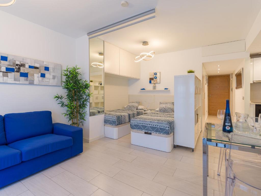 ラスパルマス・デ・グランカナリアにあるCasa Blanca Las Canterasのリビングルーム(青いソファ付)、ベッドルーム1室