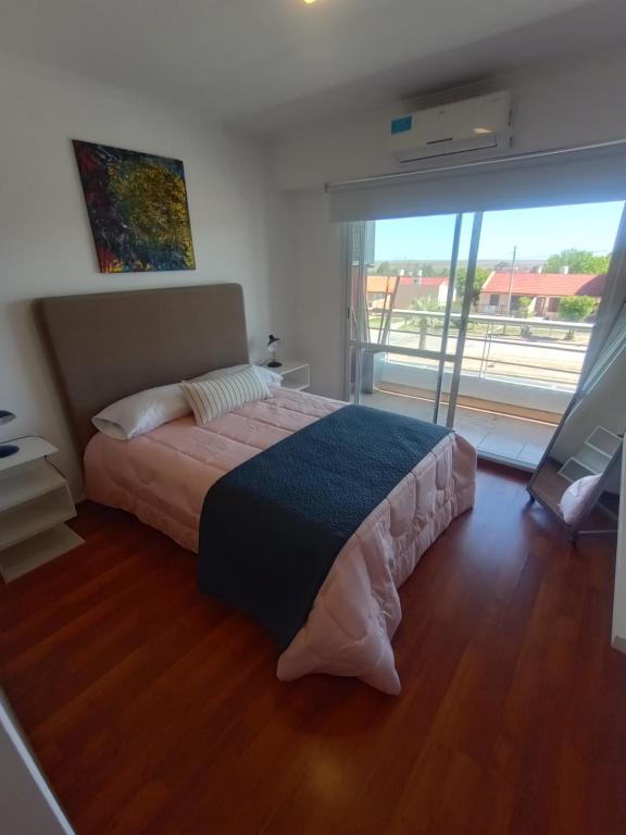 a bedroom with a bed and a large window at Colina Dom in Victoria