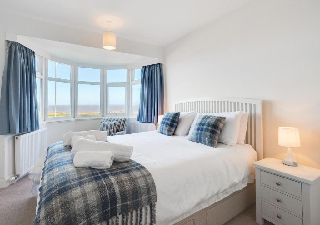 a bedroom with a large bed with blue curtains at Quebec in Cromer