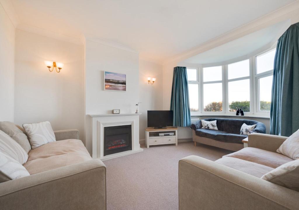 a living room with two couches and a fireplace at Quebec in Cromer