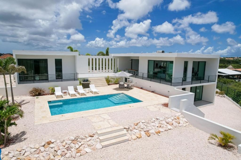 a villa with a swimming pool and a house at Charming Villa With Breathtaking View Over The Spanish Water in Willemstad
