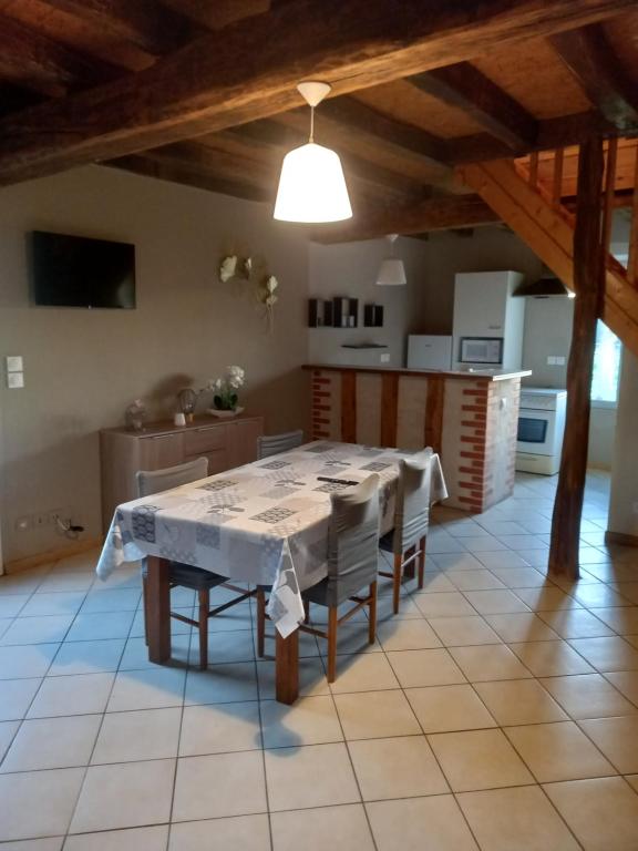 een keuken en eetkamer met een tafel en stoelen bij Chez Mimi in Trévol