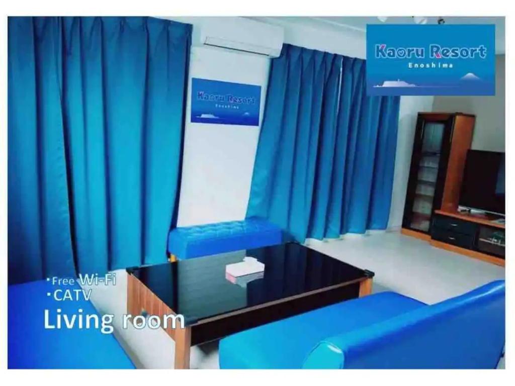 a living room with blue curtains and a table at Kaoru Resort Enoshima - Vacation STAY 08572v in Fujisawa