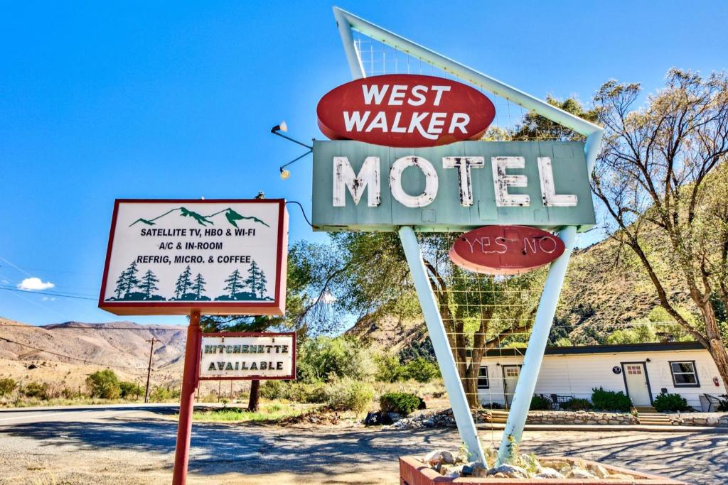 Um sinal para o motel West Walker com outros sinais. em The Historic West Walker Motel em Walker