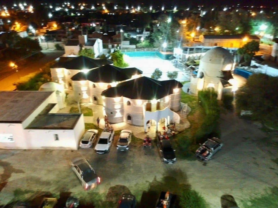 een luchtzicht op een gebouw met een zwembad in de nacht bij HOTEL CAASAMA in Santa María