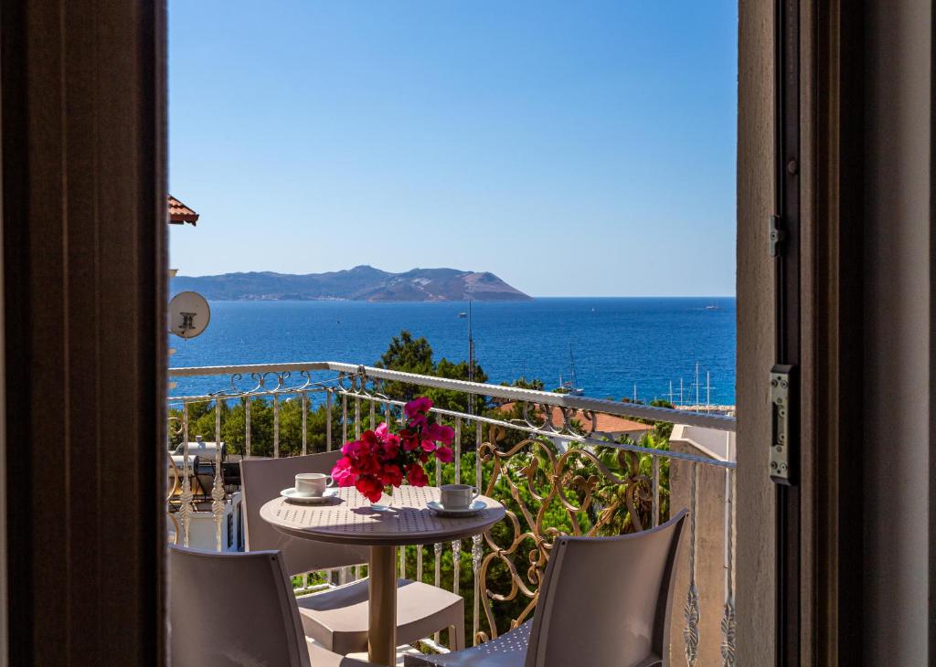 uma varanda com uma mesa e cadeiras e o oceano em Cedrus Suites em Kas