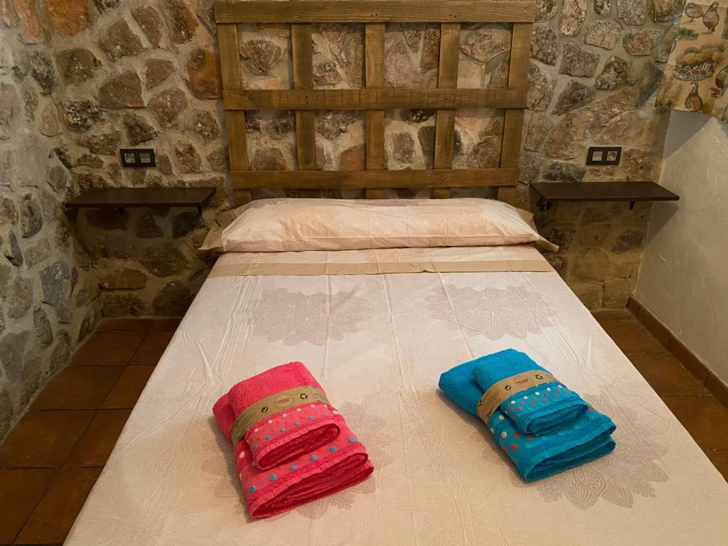 twee kussens op een bed in een kamer bij Casas Rurales La Piedra Ossa De Montiel in Ossa de Montiel