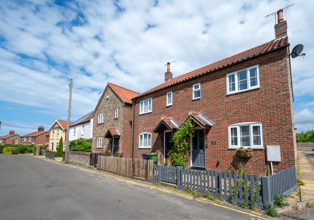 a brick house on the side of a street at Egg Cottage in Holt