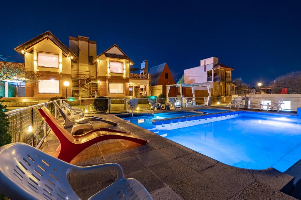 a swimming pool at night with chairs and a house at Balcón de Nono in Nono