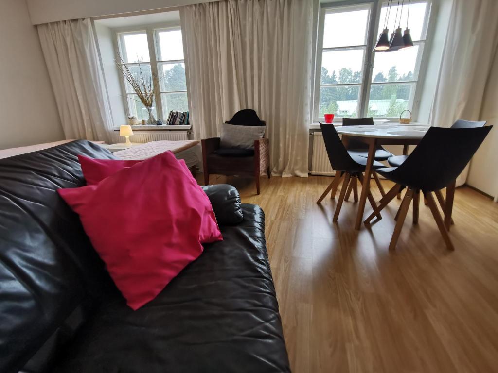 uma sala de estar com um sofá e uma mesa com cadeiras em Relaxing Beatiful Studio - Sauna Bath Facility em Kotka
