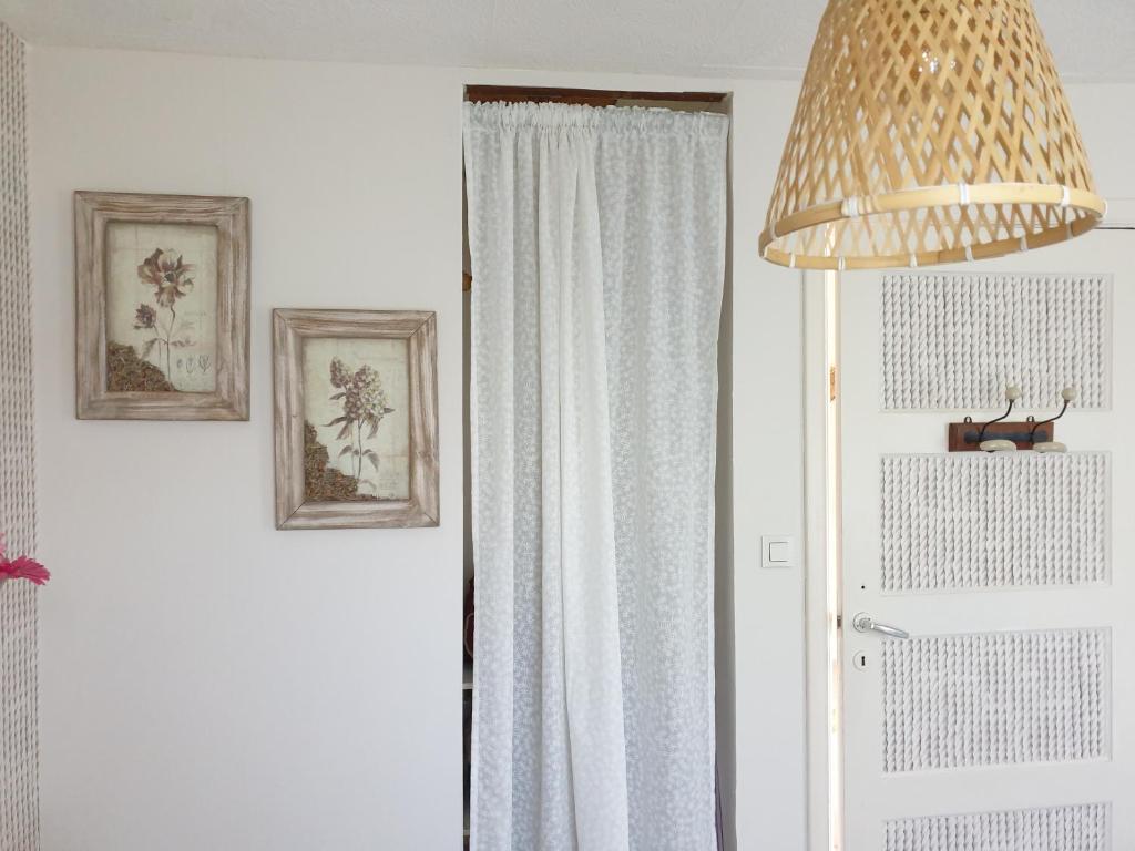 a room with a door with a curtain and a lamp at Chalet le logis des autre in Vireux-Wallerand