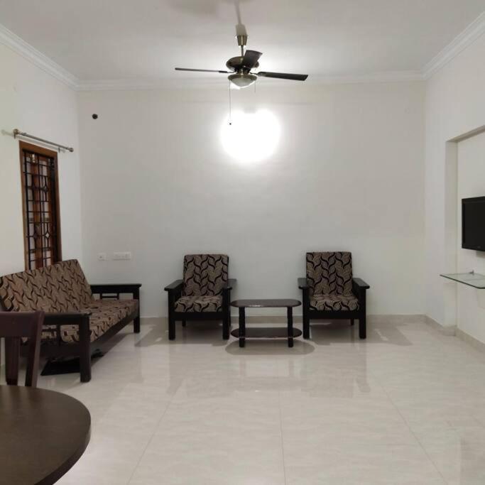 sala de estar con sillas, mesa y techo en Sapphire Luxury Apartment en Pondicherry