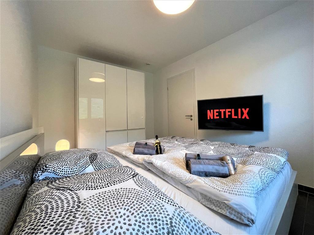 twee bedden in een slaapkamer met een netflix-bord aan de muur bij Moselpromenade Villa Moselufer, Panorama & Burg Cochem Blick, Netflix, Balkon in Cochem