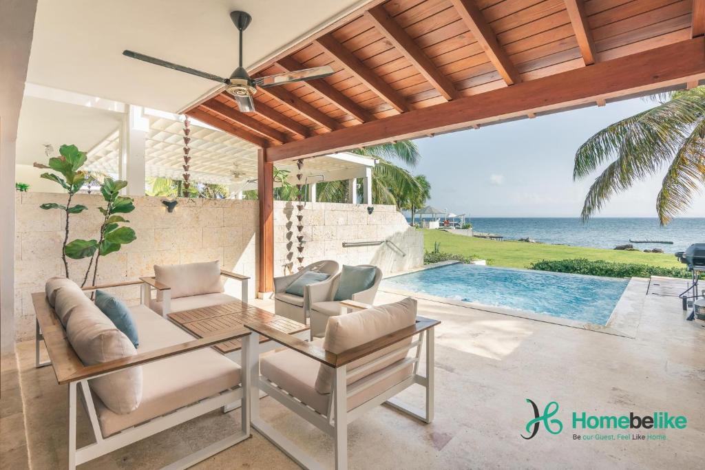 a patio with a table and chairs and a pool at 3BR Beachfront townhouse at Puerto Bahia in Los Grini