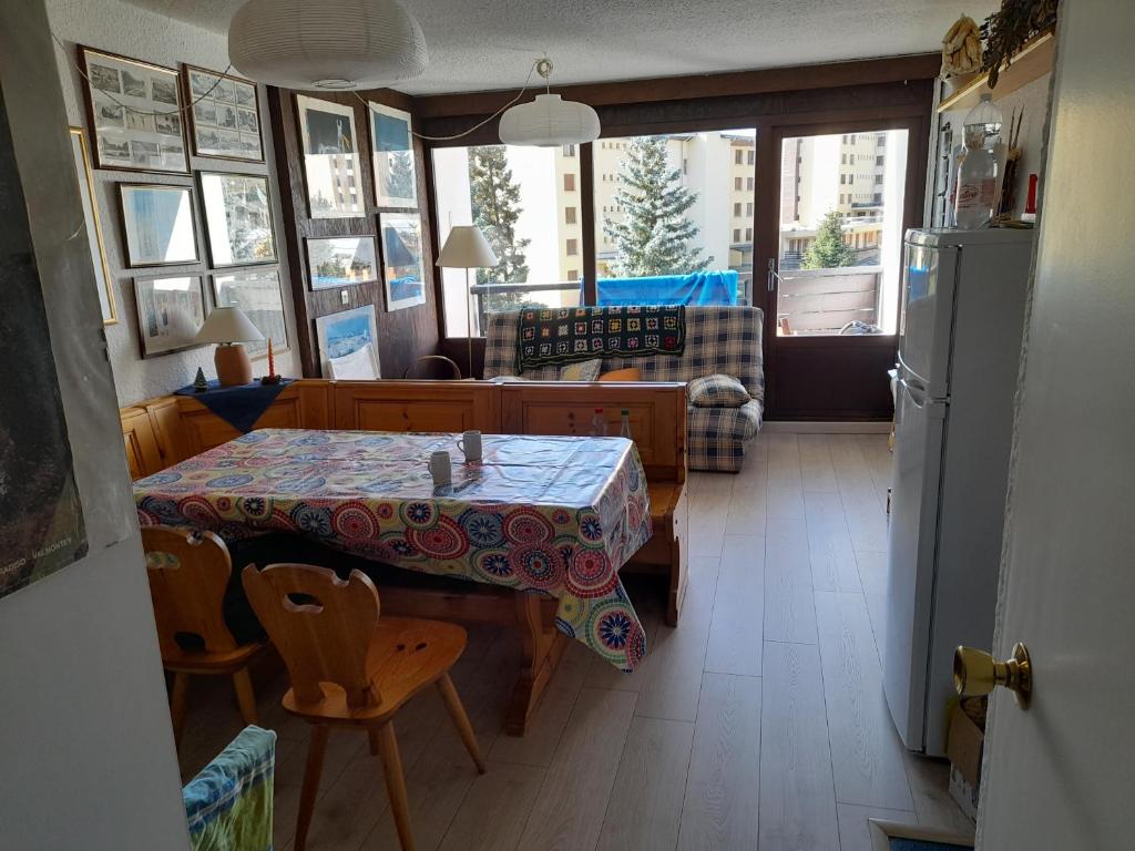 a living room with a table and a kitchen at Renardière 3 in Montgenèvre