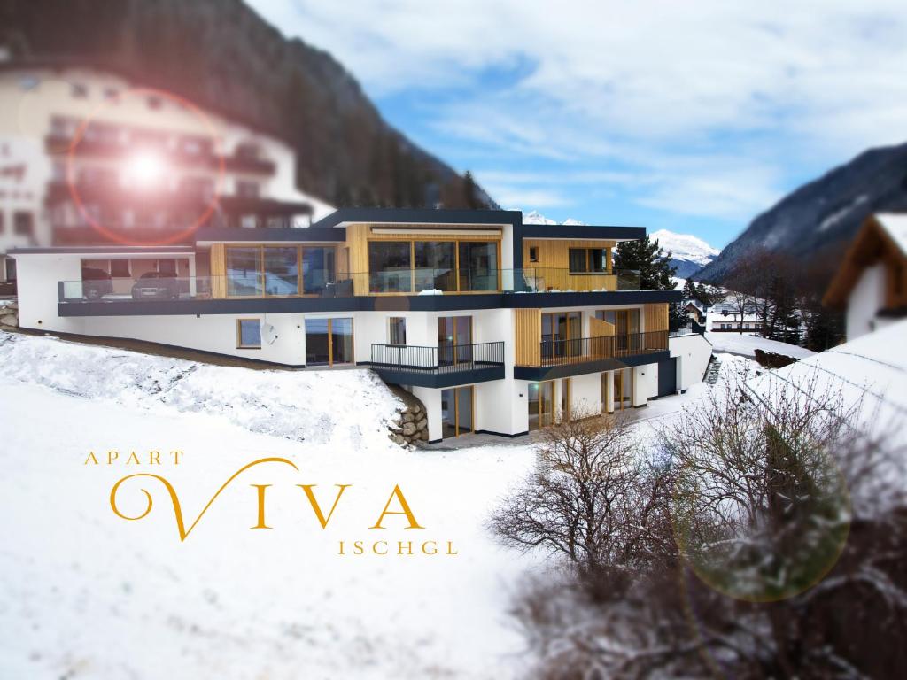 un edificio en la nieve con el sol detrás en Apart Viva Ischgl, en Ischgl