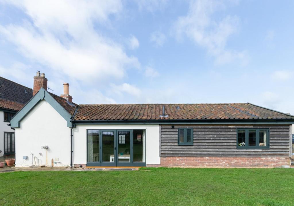 een huis met een grasveld ervoor bij The Cart Lodge in Needham