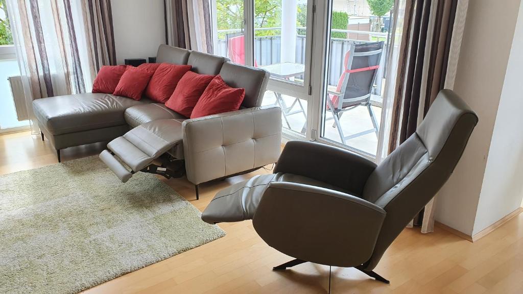 sala de estar con 2 sillas y sofá en moderne 4 Zimmer -Wohnung I BBQ I Parkplatz en Múnich