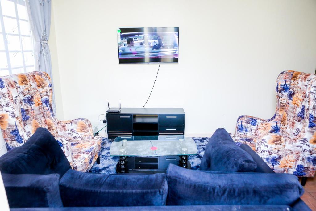 - un salon avec deux canapés et une télévision dans l'établissement Baraka Homes, à Kisumu