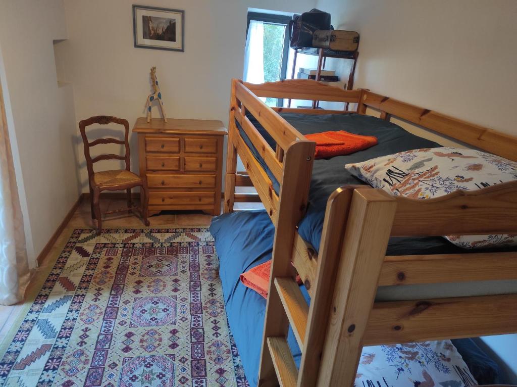 una camera con letto a castello, scrivania e sedia di Gîte au calme avec superbe vue : La Talonie a Mouret
