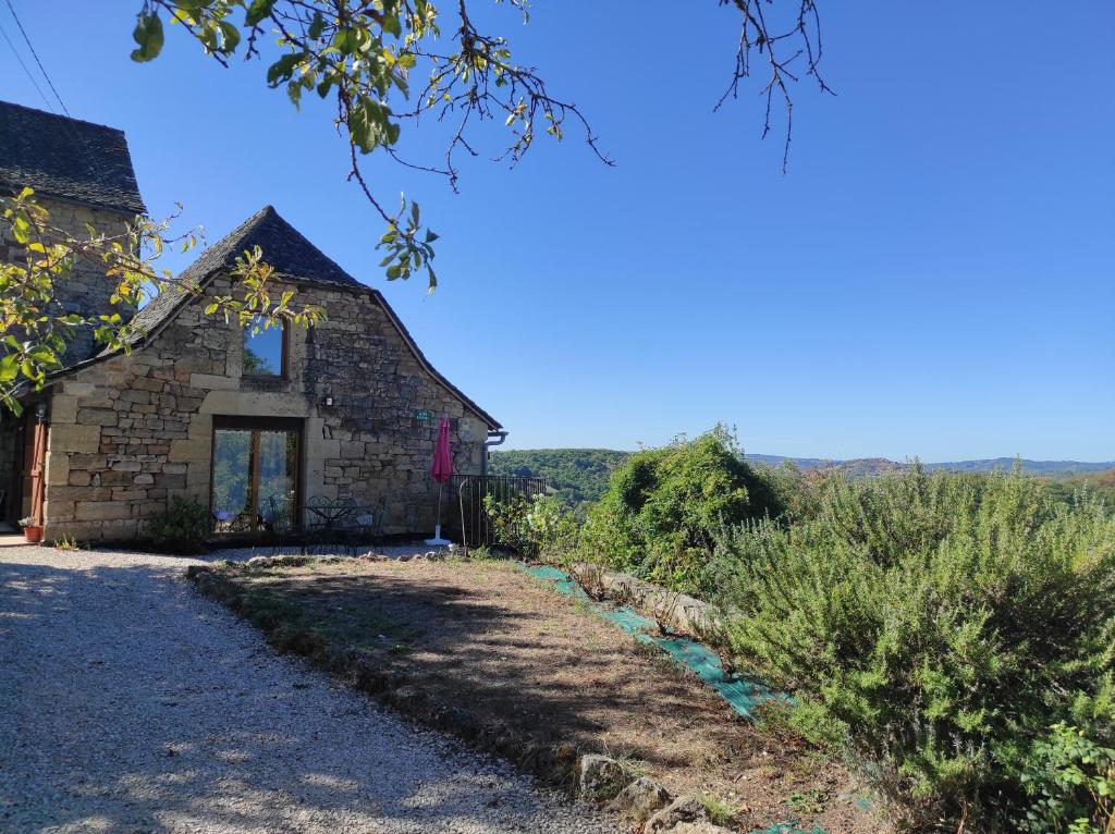 una vecchia casa in pietra con un sentiero che la porta a di Gîte au calme avec superbe vue : La Talonie a Mouret